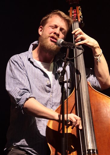 Ted Dwane, of the English folk rock band Mumford & Sons, performing at the Susquehanna Bank Center in Camden, N.J. in February. Dwane has a blood clot on his brain that will require surgery. The Grammy Award-winning folk-rock group has postponed concerts Tuesday, June 11, in Dallas, Wednesday June 12 in The Woodlands and Thursday, June 13 in New Orleans. A statement on its website said there are no plans to postpone or cancel any other appearances on the current tour. Mumford & Sons has a headlining gig Saturday at the Bonnaroo Music & Arts Festival in Manchester, Tenn. (Photo by Owen Sweeney/Invision/AP, file)