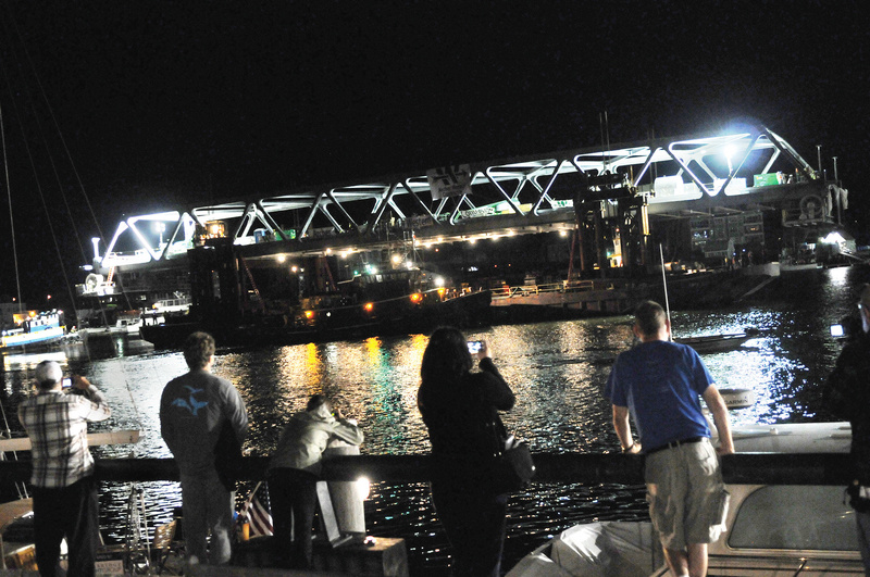 Spectators gathered as the final span of the new Memorial Bridge connecting New Hampshire and Maine floated down the Piscataqua River early Monday in Portsmouth, N.H. The bridge isn't open to traffic yet.