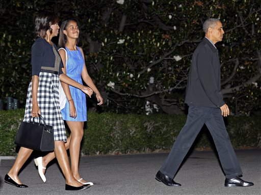 President Barack Obama, first lady Michelle Obama, and daughter Malia walk to Marine One on the South Lawn of the White House in Washington on Sunday, as they head to Northern Ireland for the G-8 Summit.