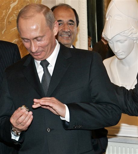 In this June 25, 2005, photo, Russian President Vladimir Putin holds a diamond-encrusted 2005 Super Bowl ring belonging to New England Patriots NFL football team owner Robert Kraft during a meeting of American business executives outside St. Petersburg, Russia.