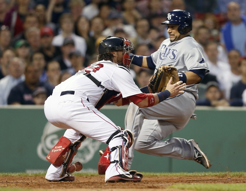 Tampa Bay Rays' Jose Molina, right, scores on an RBI single by Ben Zobrist as Boston Red Sox's Jarrod Saltalamacchia, left, waits for the throw in the fifth inning of a baseball game in Boston, Wednesday, June 19, 2013. (AP Photo/Michael Dwyer)