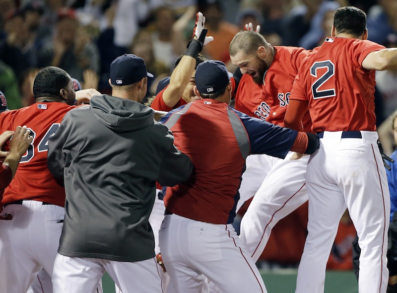 Boston Red Sox's Jonny Gomes jumps onto homeplate surrounded by teammates as he celebrates his two-RBI walk-off home run against the Tampa Bay Rays during the ninth inning of the second baseball game in a day-night doubleheader at Fenway Park in Boston, Tuesday, June 18, 2013. The Red Sox won 3-1. (AP Photo/Elise Amendola) Fenway Park