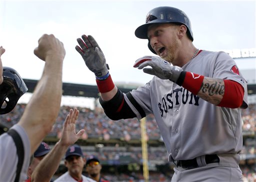 Boston Red Sox first baseman Mike Carp high-fives teammates after hitting a two-run home run in the fourth inning against the Baltimore Orioles Saturday.