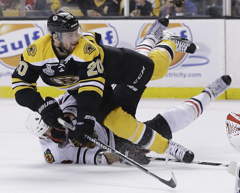 Chicago Blackhawks defenseman Niklas Hjalmarsson, bottom, of Sweden, takes down Boston Bruins left wing Daniel Paille (20) during the second period in Game 3 of the NHL hockey Stanley Cup Finals in Boston, Monday, June 17, 2013. The Bruins scored the game's second goal on the power play that followed. (AP Photo/Elise Amendola) TD Garden