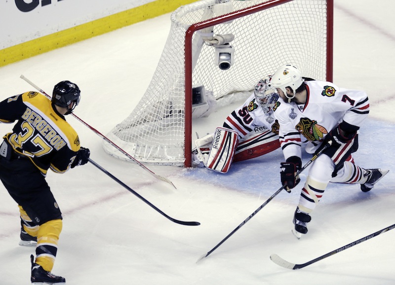 Boston Bruins center Patrice Bergeron (37) scores a goal past Chicago Blackhawks goalie Corey Crawford (50) and defenseman Brent Seabrook (7)during the second period in Game 3 of the NHL hockey Stanley Cup Finals in Boston, Monday, June 17, 2013. (AP Photo/Charles Krupa) TD Garden