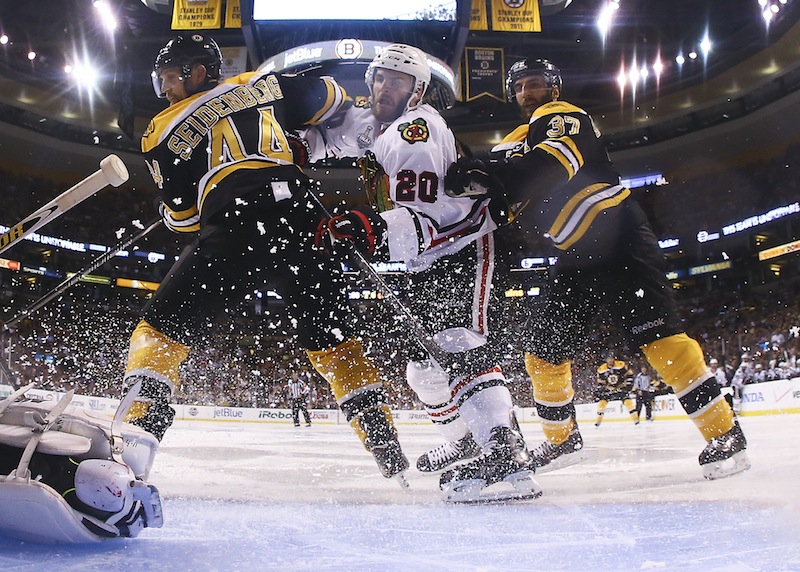 Boston Bruins defenseman Dennis Seidenberg (44), of Germany, and center Patrice Bergeron (37) check Chicago Blackhawks left wing Brandon Saad, center, in front of the goal during the second period in Game 6 of the NHL hockey Stanley Cup Finals Monday, June 24, 2013, in Boston. (AP Photo/Harry How, Pool) TD Garden