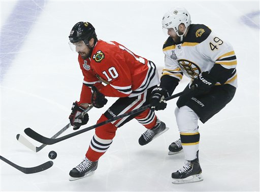 Chicago Blackhawks center Patrick Sharp fights for the puck against Boston Bruins center Rich Peverley in the first period during Game 2 of the NHL hockey Stanley Cup Finals Saturday in Chicago.