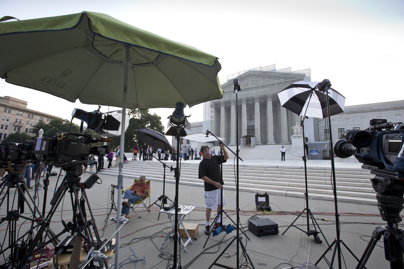 TV crews wait outside the Supreme Court in Washington as key decisions are announced Monday.