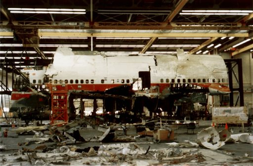 In this Nov. 19, 1997 file photo, FBI agents and New York state police guard the reconstruction of TWA Flight 800 in Calverton, N.Y. Flight 800 exploded and crashed July 17, 1996 while flying from New York to Paris, killing all 230 people aboard. Former investigators on Wednesday, June 19, 2013 called on the National Transportation Safety Board to re-examine the cause, saying new evidence points to the often-discounted theory that a missile strike may have downed the jumbo jet. (AP Photo/Mark Lennihan, File)