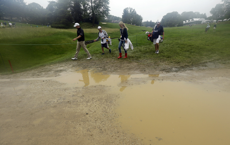 Martin Laird, left, of Scotland, walks near the fifth hole during the first round of the U.S. Open golf tournament at Merion Golf Club on Thursday in Ardmore, Pa. The course is drenched from a week of rain.