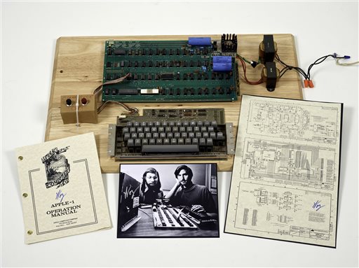 This undated photo provided by Christie's Auction House shows an Apple 1 prototype computer, built in 1976, accompanied by an operation manual and schematic as well as a photo of its inventors, Steve Wozniak, left, and Steve Jobs.