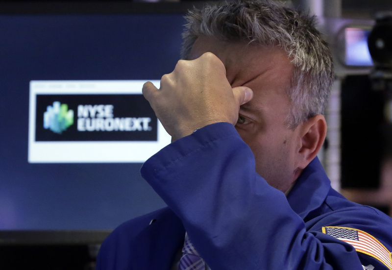 Specialist Christopher Culhane squeezes his forehead as he works on the floor of the New York Stock Exchange on Thursday.