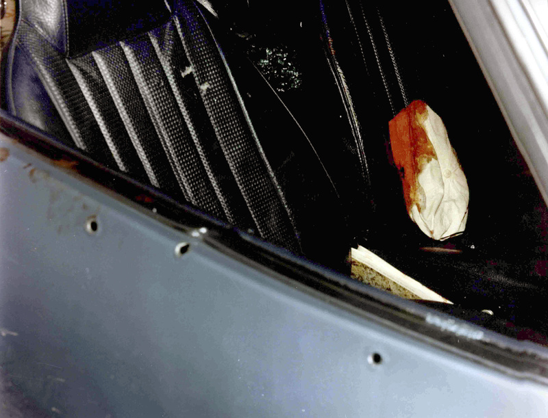 This photo presented as evidence Wednesday during the trial of James "Whitey" Bulger in U.S. District Court in Boston shows a car with bullet holes in the door and a bloody cap on the seat.
