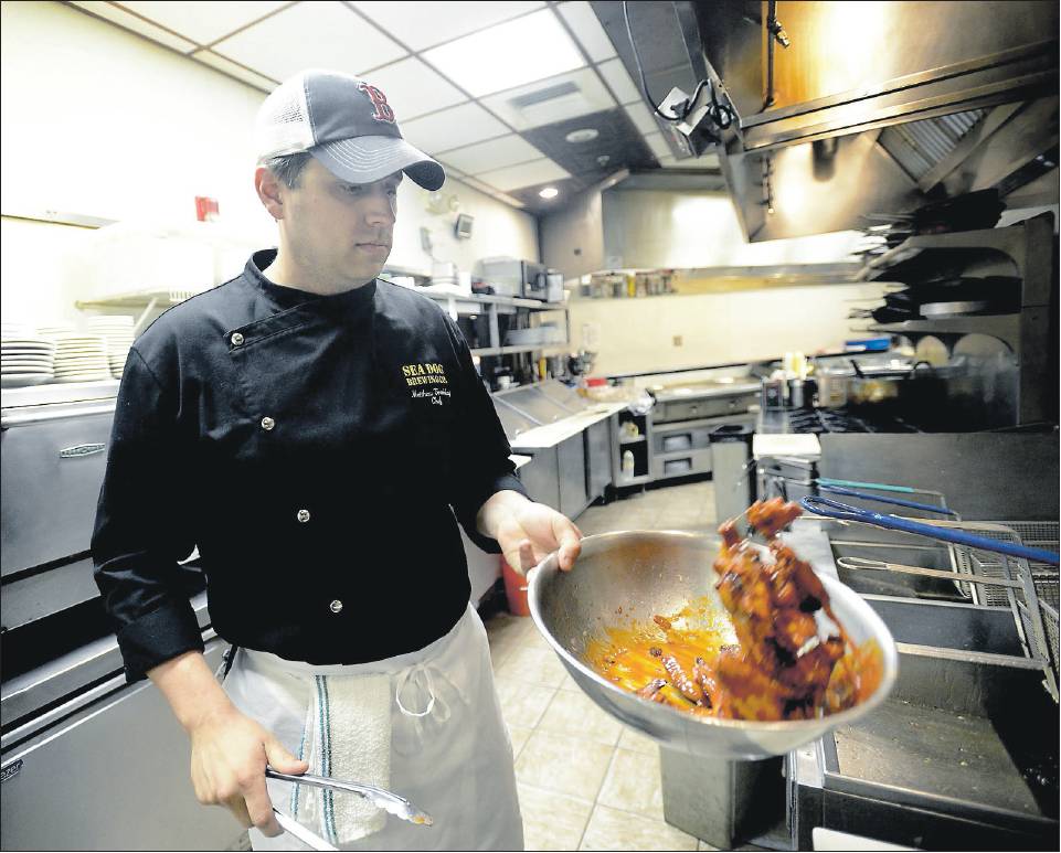 Chef Matthew Tremblay tosses a batch of wings at Sea Dog Brewing Co. in South Portland. Tremblay will compete in the second annual Hot Wing Cook-Off Challenge on June 22.