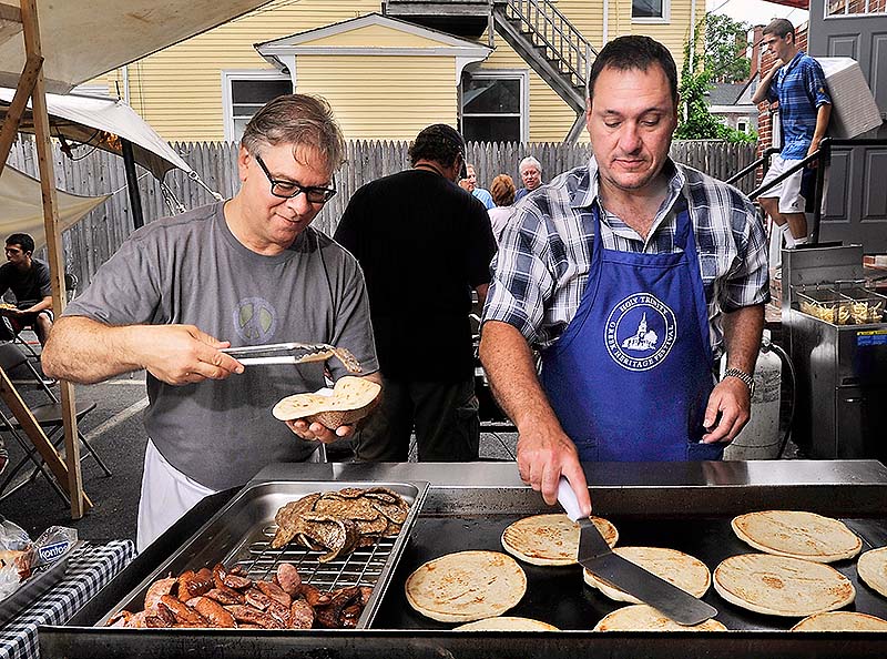Bill Doukas, left, and Tim Morrell make the very popular gyros, about 200 an hour according to Doukas, for visitors Saturday at the Greek Food Festival at the Holy Trinity Greek Orthodox Church in Portland.