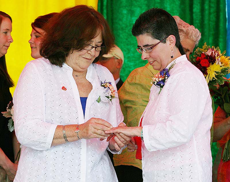 Rose Larkin, left, puts a ring on Deb DeTuccio's finger during a mass wedding held Saturday in Deering Oaks Park in Portland as part of the Pride Parade and festival.
