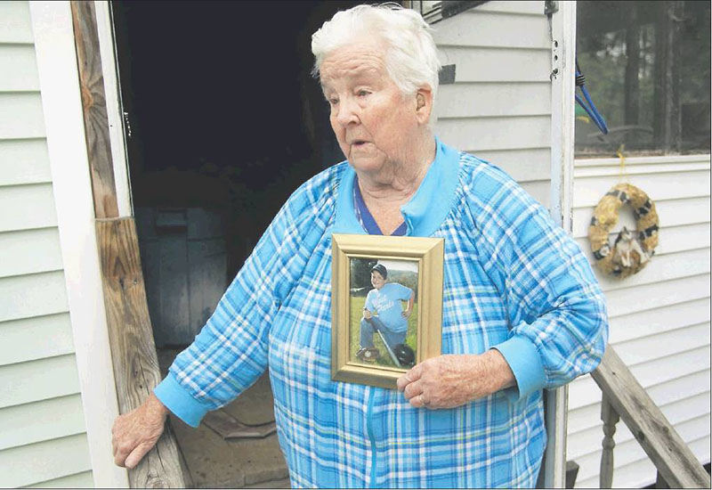 Eleanor Paine of West Paris holds a picture of her grandson, James Reynolds, when he was younger as she talks to a reporter Monday outside her home. She said that when Reynolds’ mother was at work, her son often spent time at Paine’s house.
