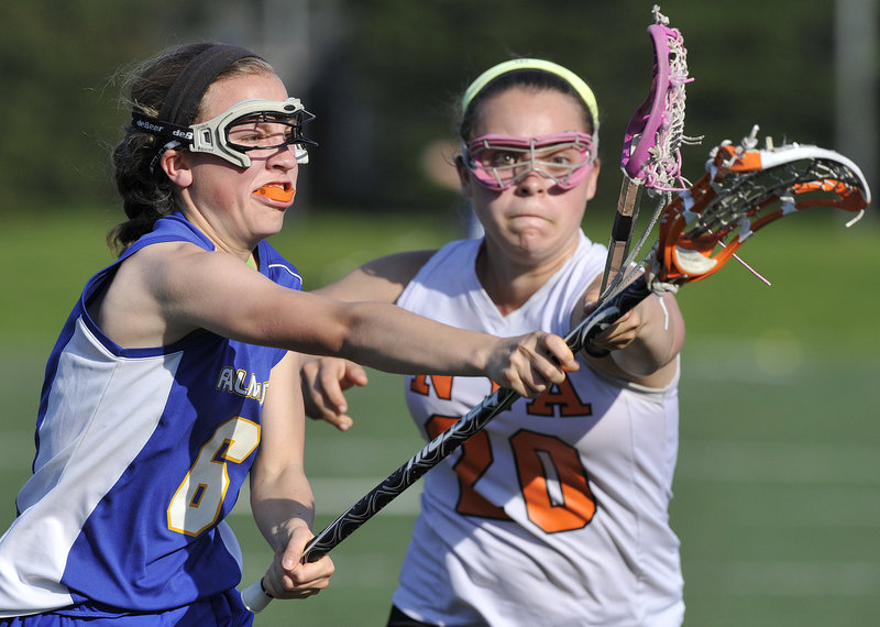 London Bernier, left, of Falmouth attempts to get off a shot Friday while defended by Shelby Peavey of North Yarmouth Academy during their schoolgirl lacrosse regular-season finale. Falmouth won 21-10 and will be at York in the first round of the playoffs. NYA’s season came to an end.