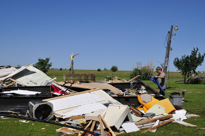 An El Reno, Okla., resident searches through the wreckage of a friend’s mobile home after Friday’s tornado, hoping to find undamaged belongings in El Reno on Saturday.