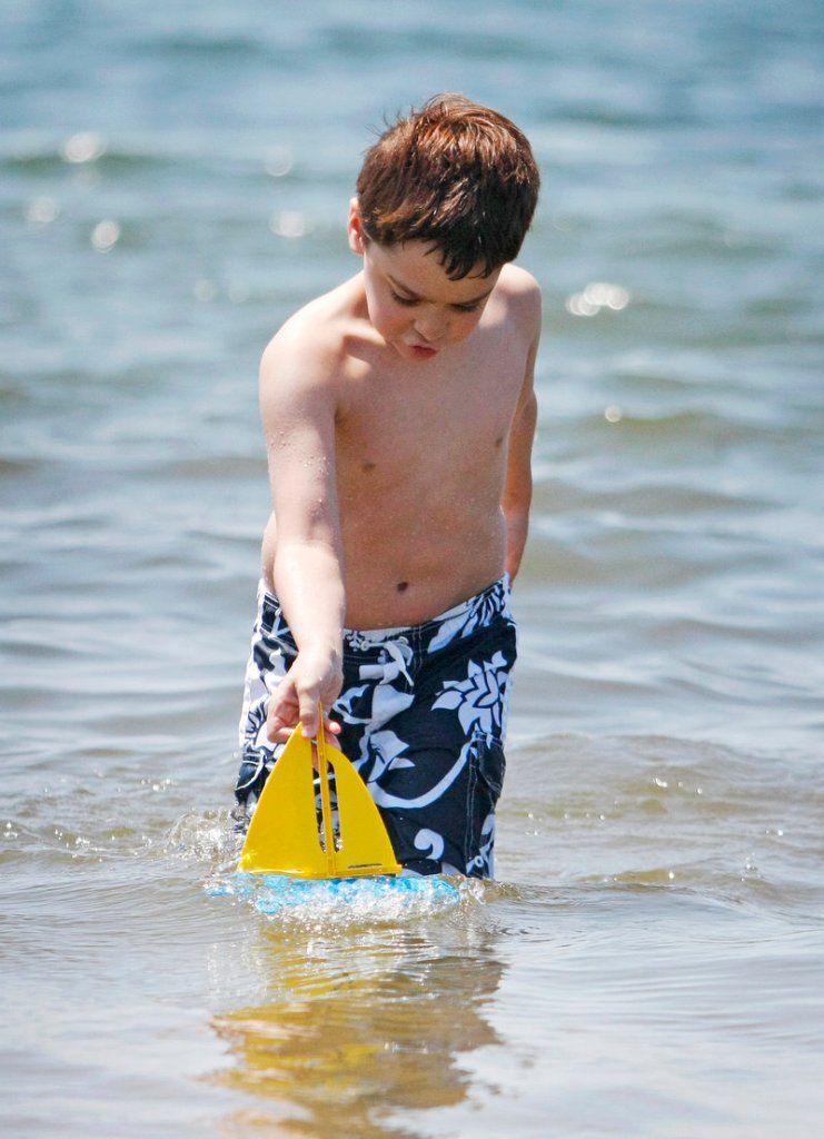 Abe Sullivan, 9, of Portland gives his toy sailboat a try Sunday at Kettle Cove in Cape Elizabeth. Abe was visiting the beach with his mother, Julie, and his sister, Sara, 8.