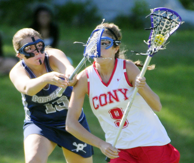 Ashley Frank, left, of Portland tries to stop Cony’s Josie Lee as she breaks toward the goal during their Eastern Class A lacrosse semifinal Wednesday in Augusta. Fourth-seeded Cony advanced with a 12-8 victory.