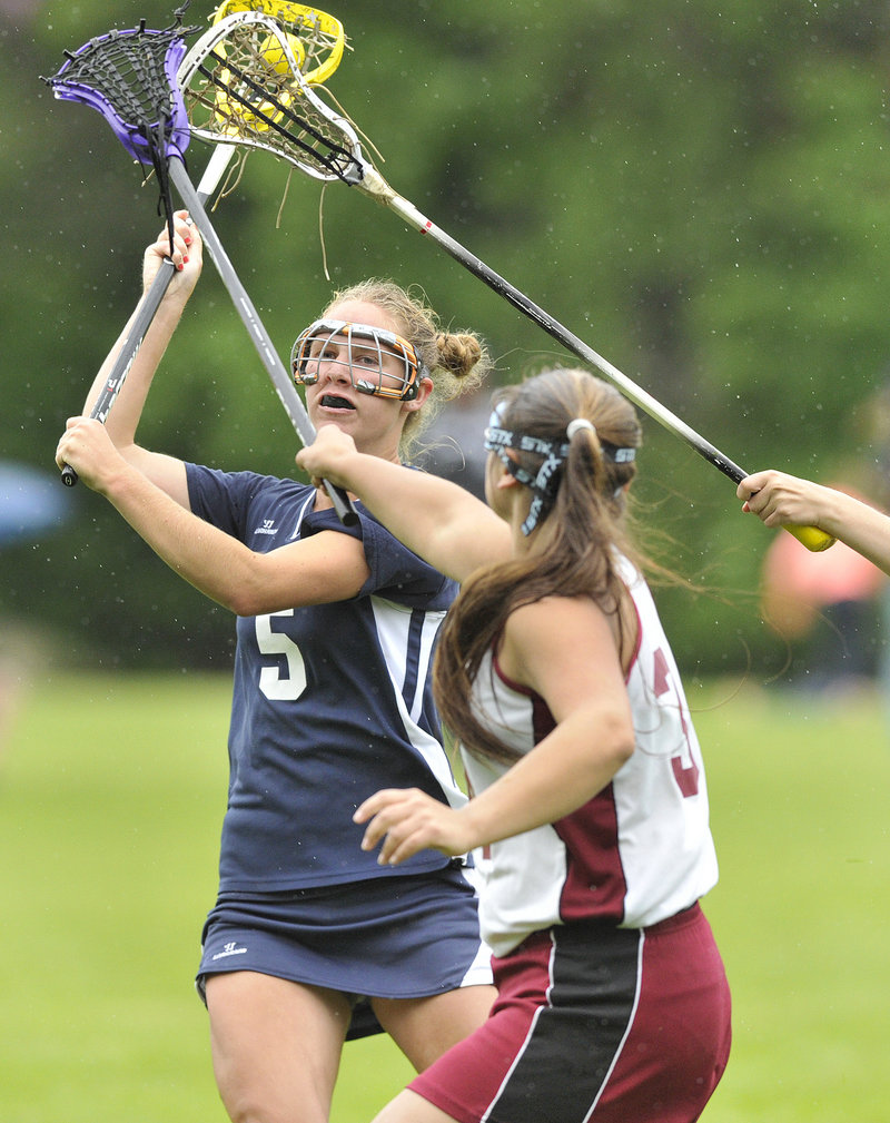 Alex Lucas of Yarmouth, left, gets off a shot Friday while defended by Megan Peacock of Freeport during the Eastern Class B girls' lacrosse semifinal.