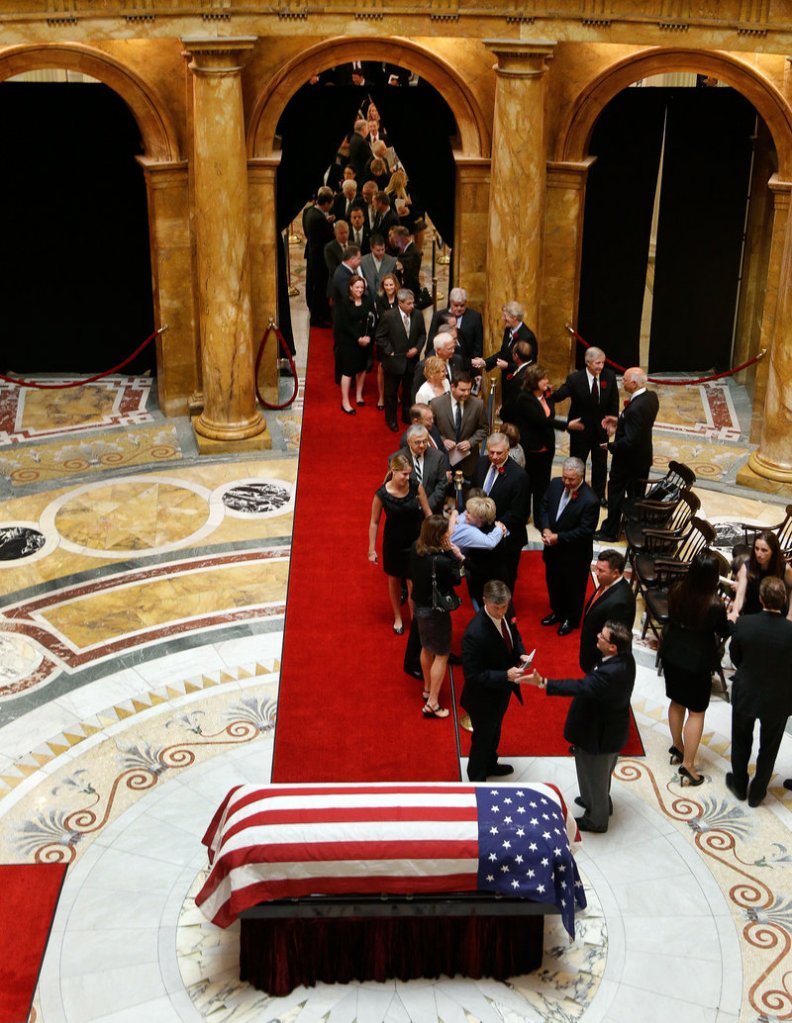 The flag-draped casket of former Massachusetts Gov. Paul Cellucci lies in repose in the Hall of Flags as mourners line up to pay their respect at the Statehouse in Boston on Thursday. Cellucci died Saturday at his home in Hudson from complications of ALS, also known as Lou Gehrig's disease.