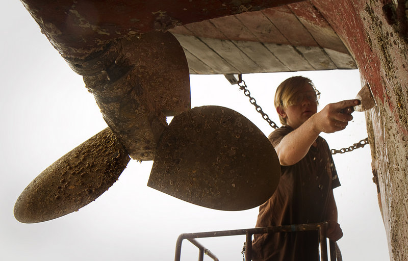 Crew member Andrew Duzs, of the former slave ship Amistad, scrapes barnacles from the hull in dry dock at Gowen Marine in Portland on Thursday June 13, 2013.