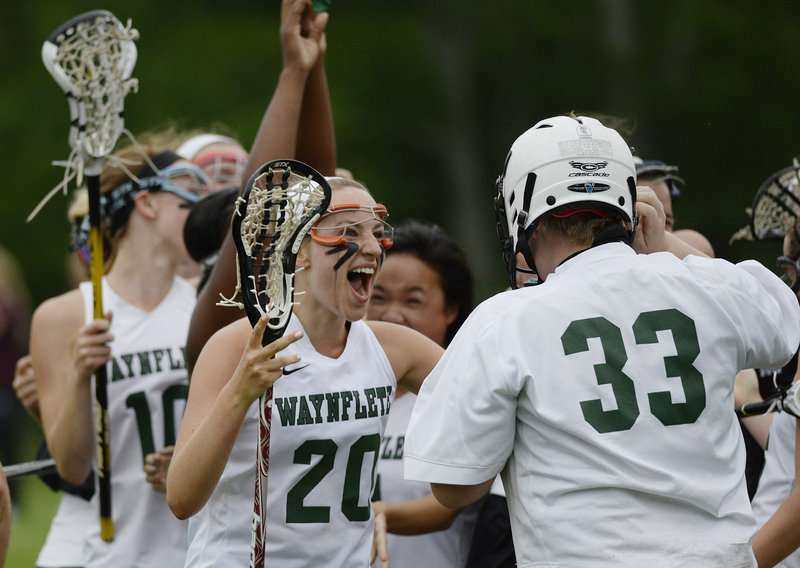 Cat Johnson, 20, of Waynflete rushes to celebrate with goalie Katherine Torrey after the 16-9 victory against Cape Elizabeth put the Flyers into the Class B girls’ lacrosse state championship game Saturday against Yarmouth.