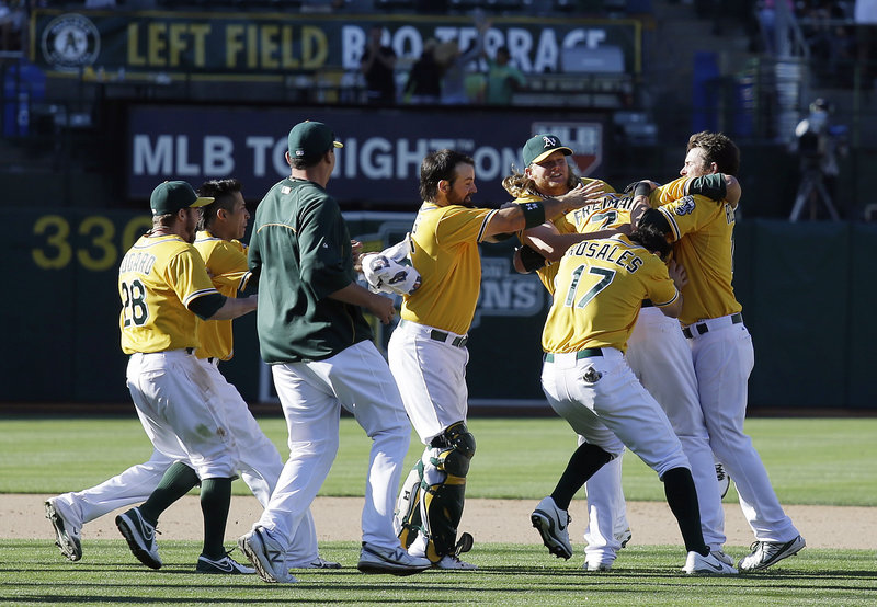 Oakland’s Nate Freiman, second from right, is mobbed after hitting a game-winning RBI single off New York Yankees pitcher Mariano Rivera in the 18th inning Thursday at Oakland.