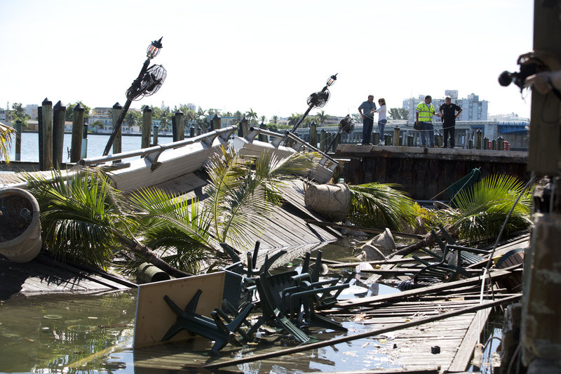 Officials begin their inspection of the outdoor deck that collapsed at Shuckers Bar & Grill. The packed outdoor deck behind the popular Miami-area sports bar partially collapsed during the NBA Finals on Thursday night, sending dozens of patrons into Biscayne Bay.