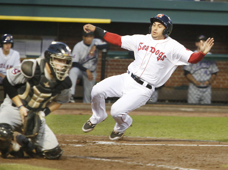 Ryan Dent of the Sea Dogs slides into the plate Friday night to score on a single by Heiker Meneses in the fourth inning of a 6-2 loss to the Akron Aeros at Hadlock Field. The catcher is Jake Lowery.