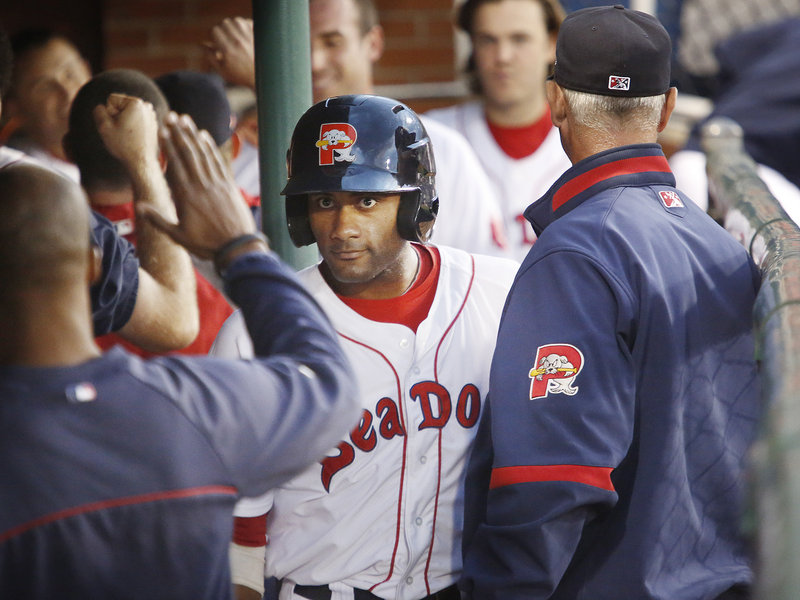 Tony Thomas of the Sea Dogs is congratulated in the dugout Friday night after scoring in the fourth inning of a 6-3 loss to the Akron Aeros.