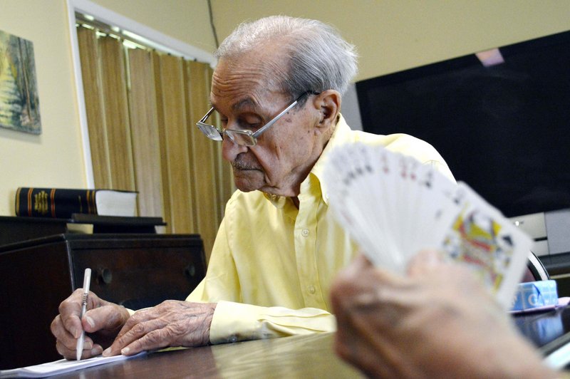 Joe Tuzzo keeps score while playing bridge at the Claire Teague Senior Center. Tuzzo is considered the man to beat when it comes to the monthly wordsmith competition at the center.