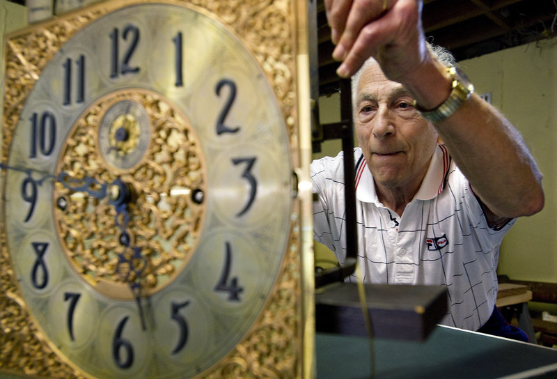 Jerry Fishman examines a valuable calendar clock in the basement workroom of his home in Stamford, Conn. Fishman, one of the last repairmen of his kind in Stamford, has retired after decades in the clock repair business.