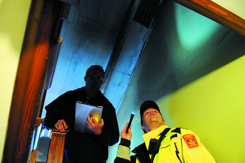 Augusta Code Enforcement Officer Robert Overton, left, and Augusta firefighter Arthur True inspect an apartment in the city. Several buildings throughout the city of Augusta have been cited for safety shortcomings.