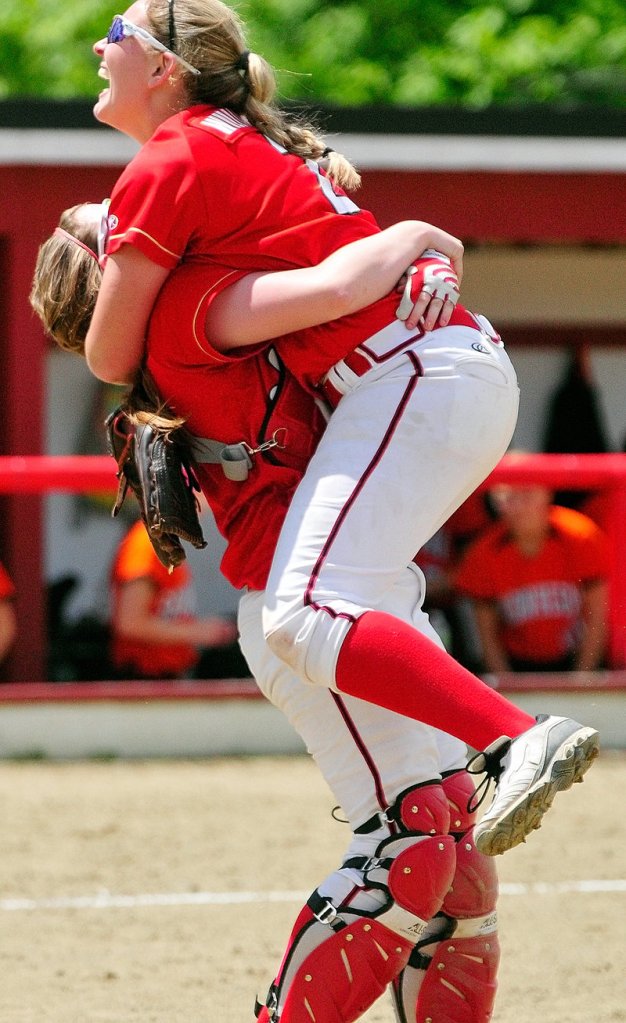 Alyssa Williamson receives a hug from catcher Megan Murrell after pitching Scarborough to the Class A state title, beating Skowhegan, 9-3.