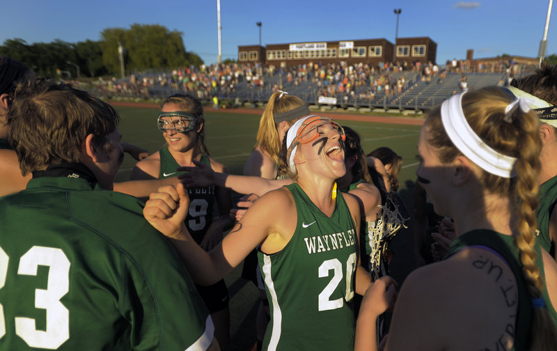 Cat Johnson rejoices with her Waynflete teammates after the Flyers capped an unbeaten season with a 7-4 win over Yarmouth in the Class B lacrosse final.