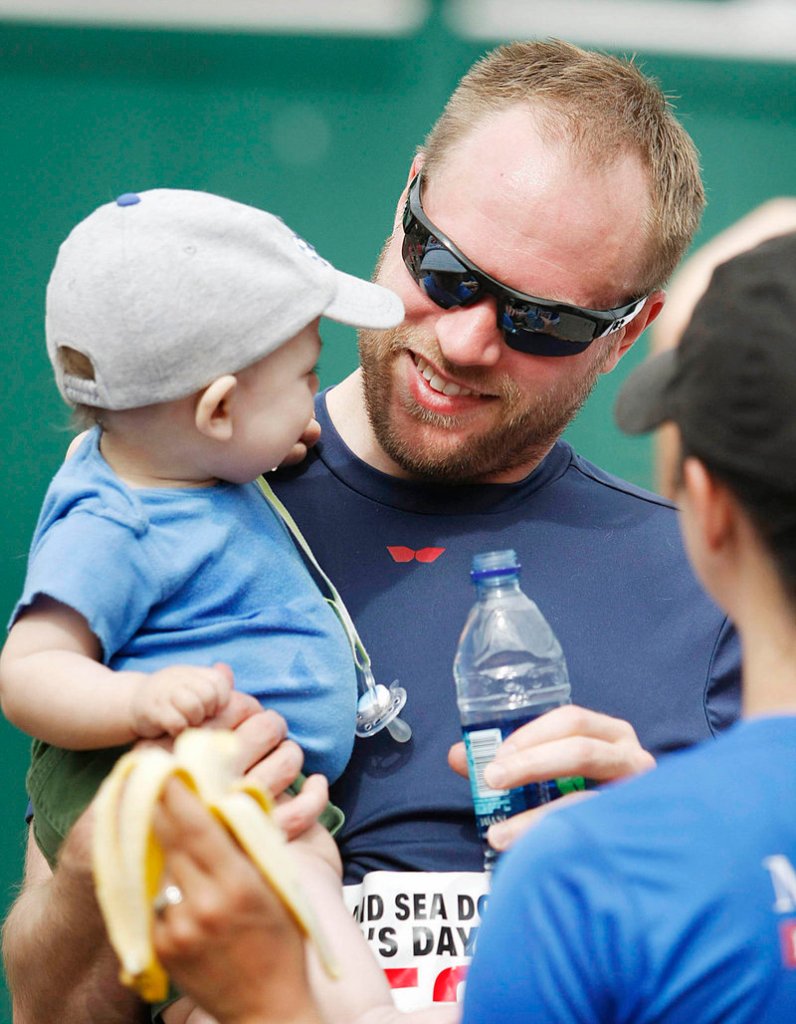Jason Worswick of South Portland holds his young son, Griffin, after running the Portland Sea Dogs Father's Day 5K Sunday.