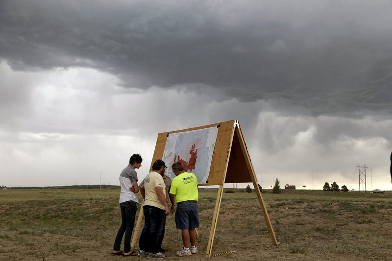 Residents look at a map detailing progress of the Black Forest wildfire Sunday in Colorado Springs, Colo. Fire crews were putting out hot spots Sunday in the Black Forest.