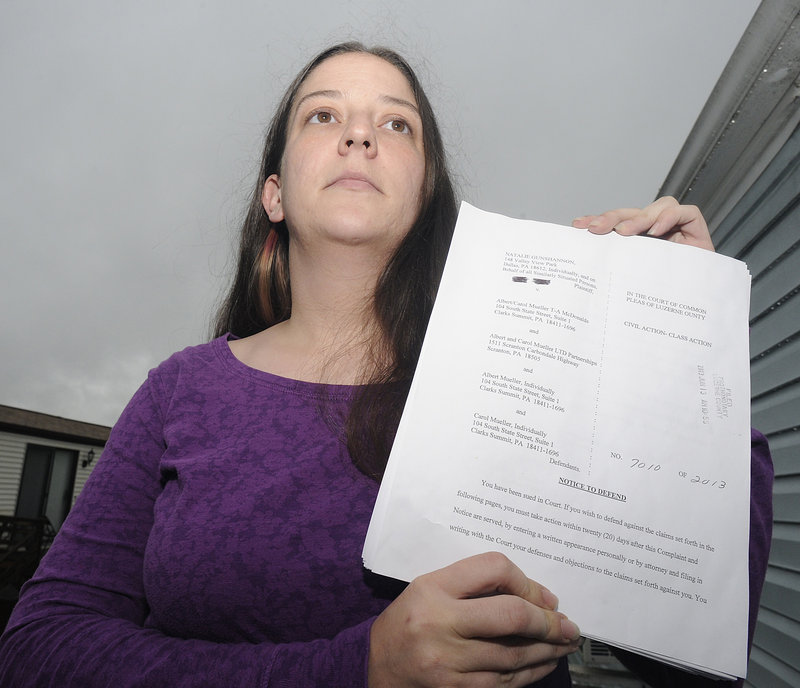 Natalie Gunshannon holds a copy of a lawsuit filed against the owners of a McDonald’s franchise.