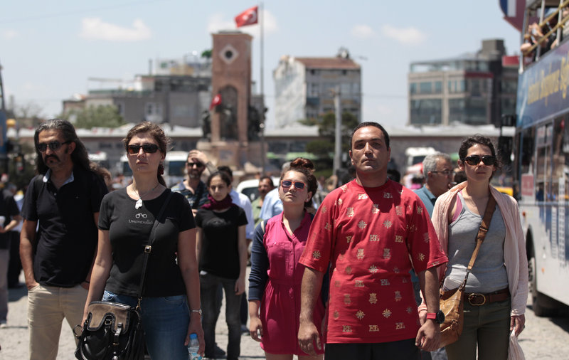 Protesters stand in a silent protest Tuesday at Taksim Square in Istanbul, Turkey. After weeks of unrest, Turkish protesters have found a new form of resistance: standing still and silent.