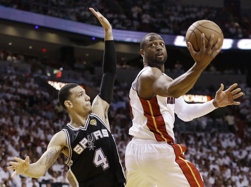Dwyane Wade of the Miami Heat puts up a shot Tuesday night while guarded by Danny Green of the San Antonio Spurs during Game 6 of the NBA finals at Miami. The Heat came back to force Game 7 with a 103-100 victory in overtime.