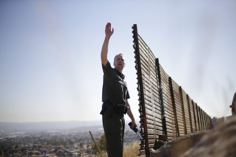 Border agent Jerry Conlin mans his post Wednesday with Tijuana, Mexico, behind him. Key senators are hopeful that they’re closing in on a bipartisan agreement to toughen border security and offer a path to citizenship.