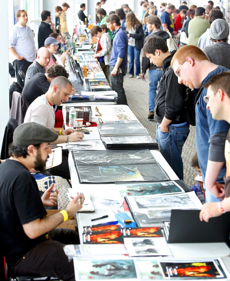 Illustrators Christian Dibari, bottom left, and Sean Murphy above left, discuss their art at the Maine Comics Arts Festival in Portland in May. Events like comic book conventions give "nerds" a chance to have fun with those who share their interests.