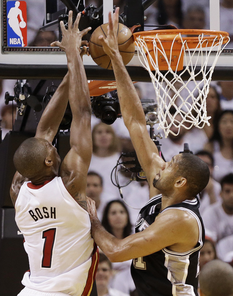 Tim Duncan of the San Antonio Spurs knocks away a shot by Chris Bosh of the Miami Heat – make that the champion Miami Heat – in Game 7 of the NBA finals Thursday night.