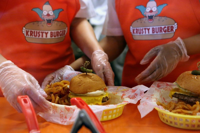 Krusty Burger employees prepare “The Simpsons” characters’ beloved burgers at the Universal Orlando amusement park, in Orlando, Fla.