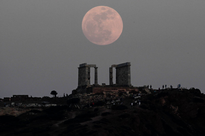 Gracing the sky above the Temple of Poseidon in Cape Sounion, Greece, is a classic “supermoon.”