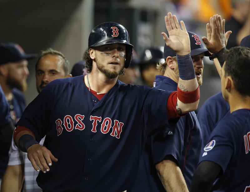 Jarrod Saltalamacchia of the Boston Red Sox gets the welcome-home from teammates in the dugout after scoring on Shane Victorino’s grounder in the eighth inning of a 10-6 victory against Detroit Friday night.