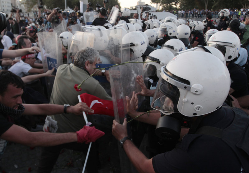 Riot policemen push protesters during clashes at Taksim Square in Istanbul on Saturday. The protesters were honoring the memory of four people killed in previous protests.